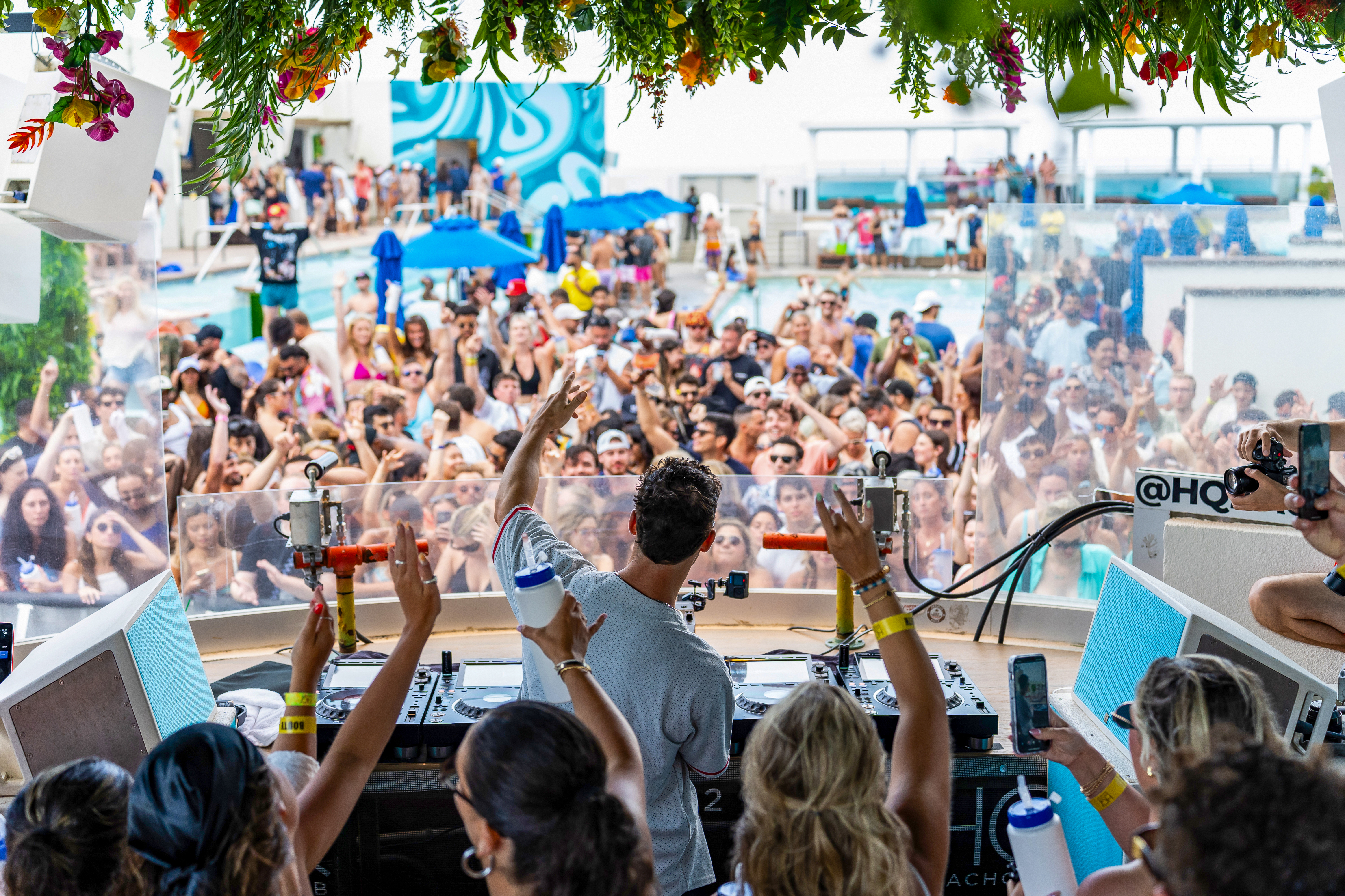 DJ performing at HQ2 Beach Club overlooking a lively summer crowd at Ocean Casino Resort.