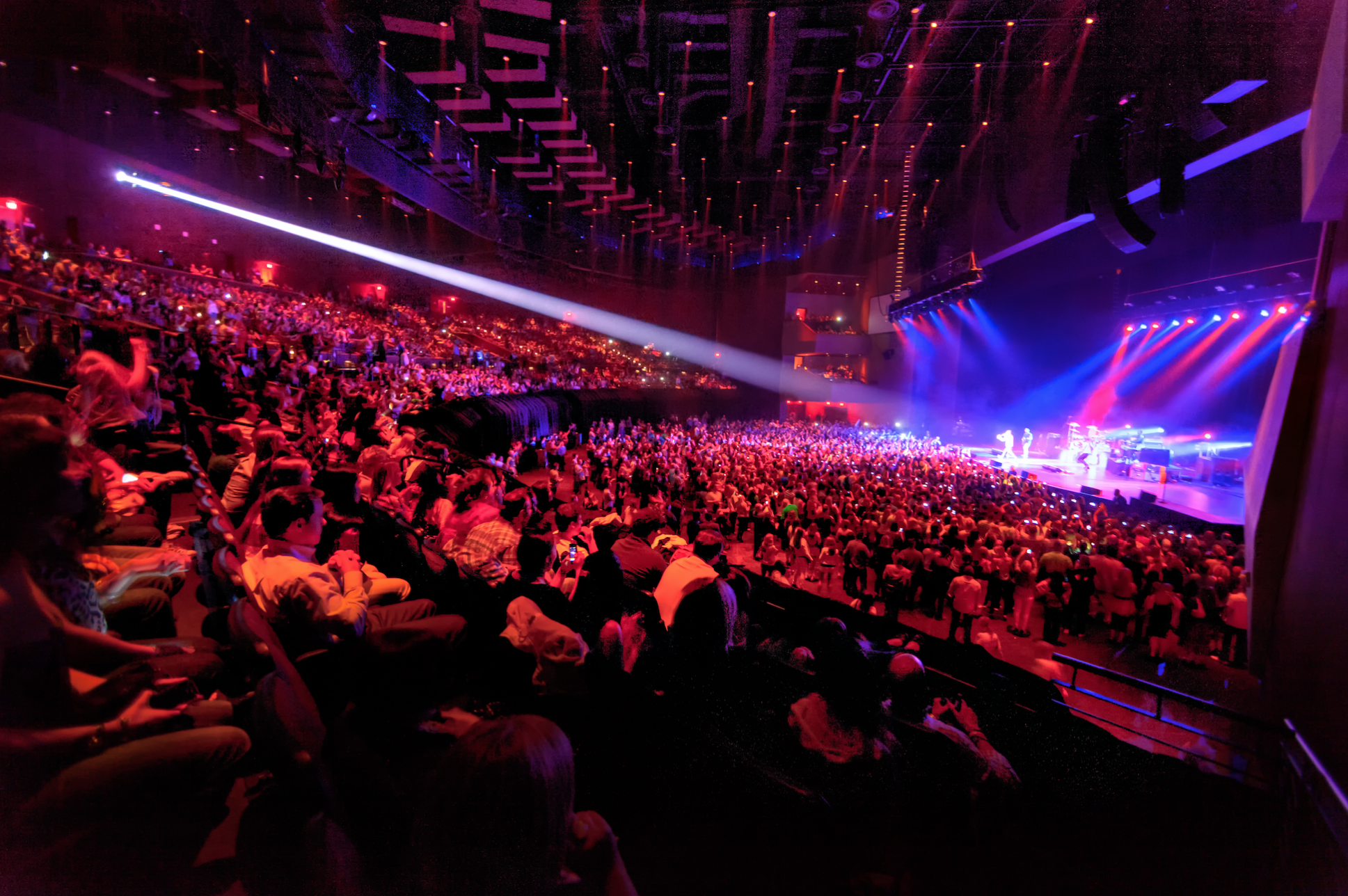 Wide-angle view of a sold-out concert at Ovation Hall at Ocean Casino Resort, with a sea of fans under dramatic stage lighting.