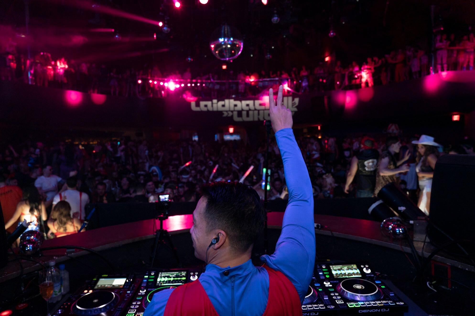 DJ performing in front of a packed crowd under vibrant pink lights for Halloween at HQ2 Nightclub at Ocean Casino Resort.