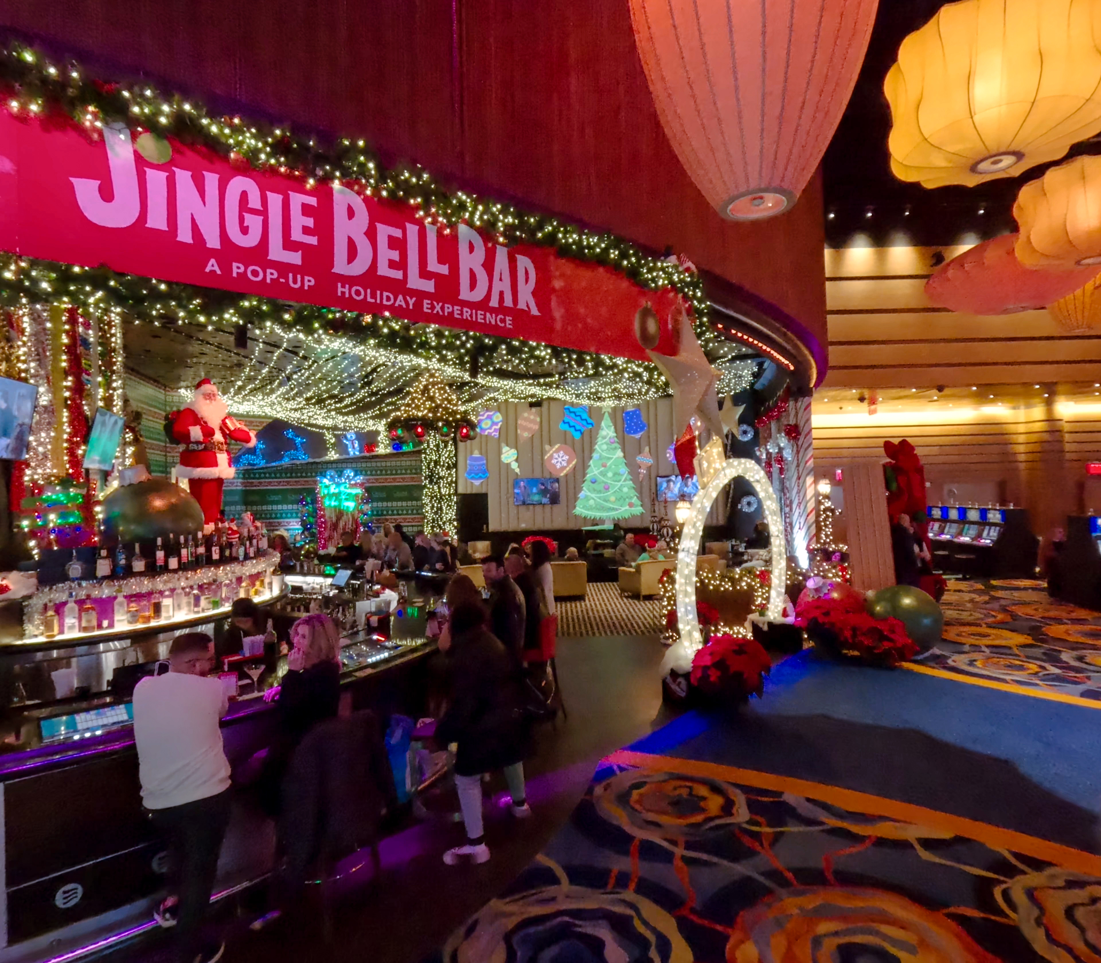 Holiday-themed Jingle Bell Bar at Ocean Casino Resort featuring twinkling lights, Christmas décor, and a lively crowd.