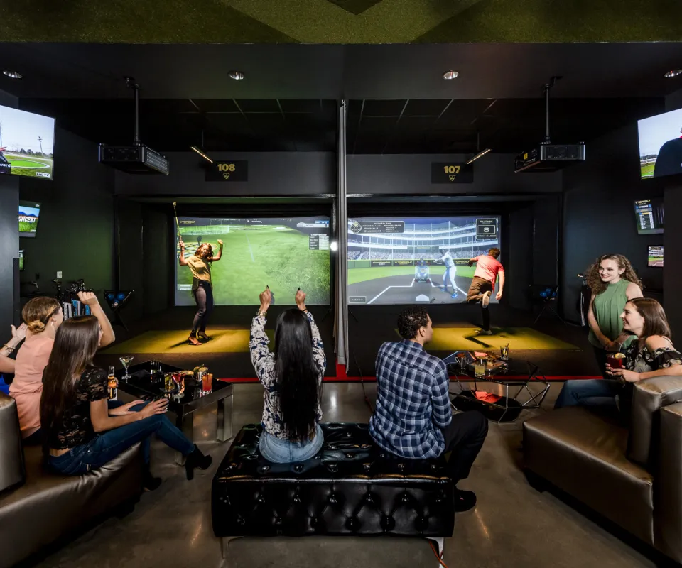 group of adults playing virtual games in the Top Golf Swing Suite