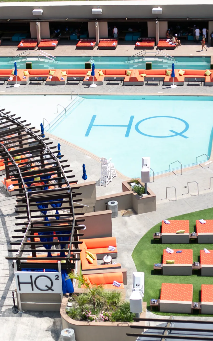 Aerial view of HQ² Dayclub at Ocean Casino Resort, featuring a sparkling pool surrounded by orange loungers and private cabanas.