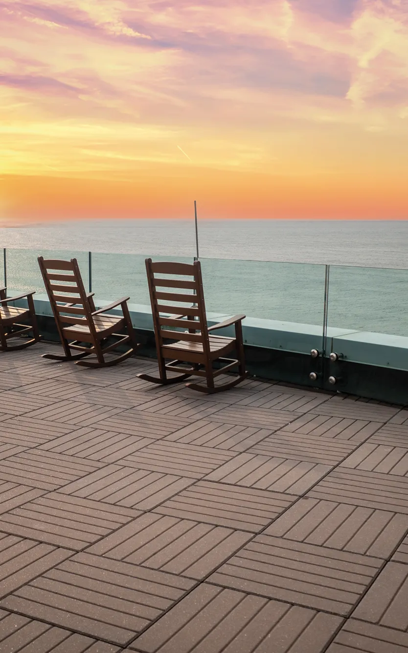 Rocking chairs overlooking the Atlantic Ocean at sunset from The Park at Ocean Casino Resort.