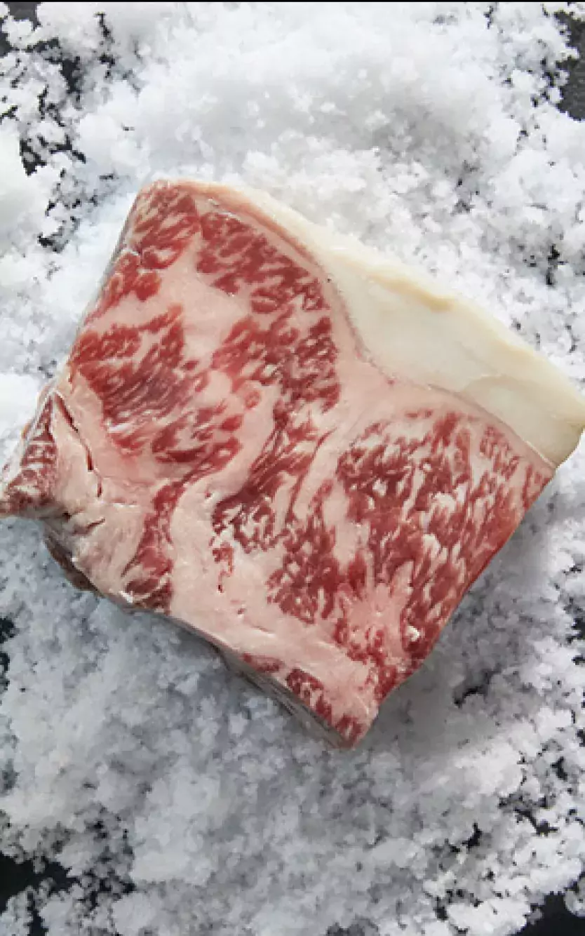 Wagyu Beef cut on a table next to an image of the upscale dining room at American Cut