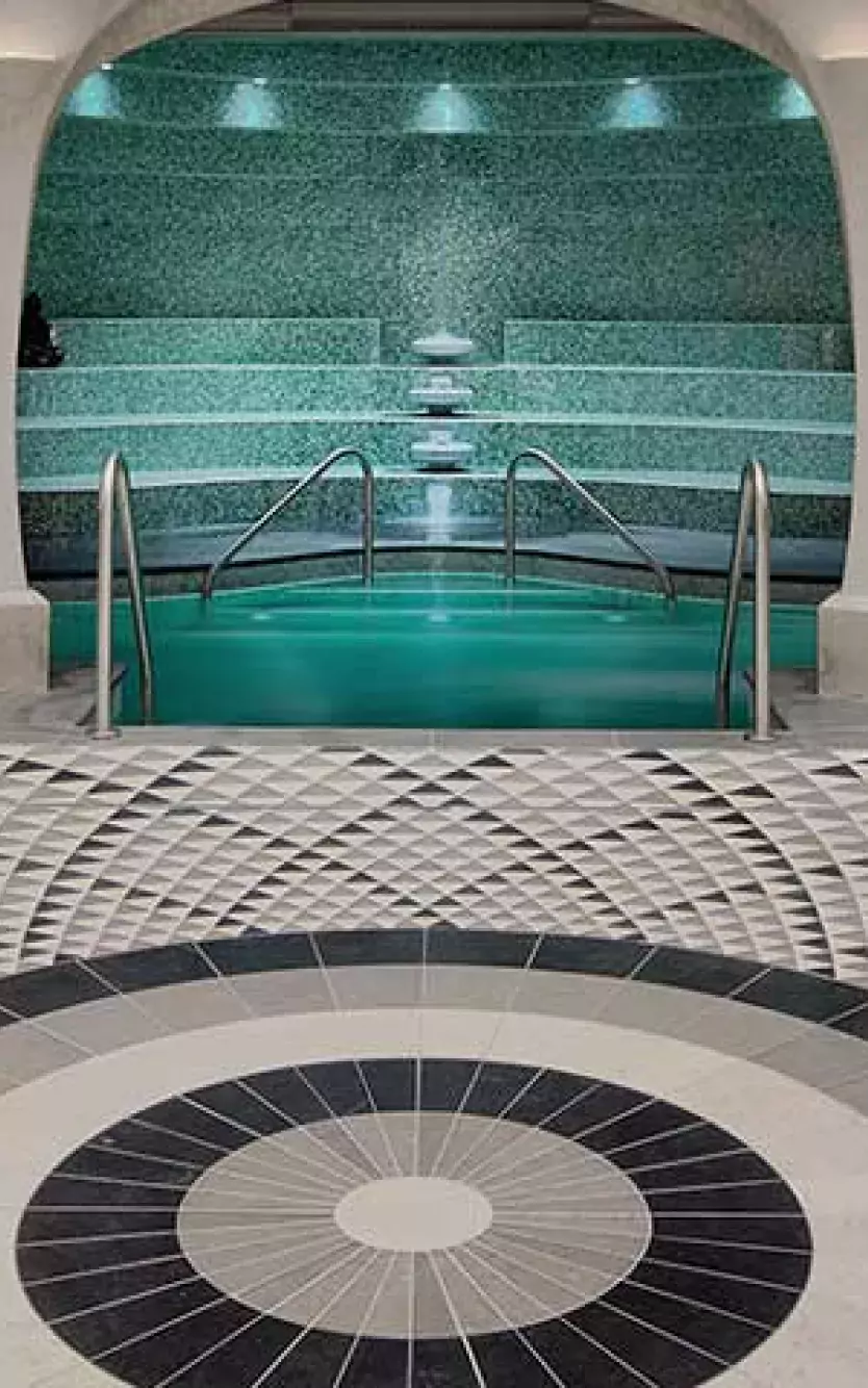 Tiled lounge area in with archways leading to spa pool