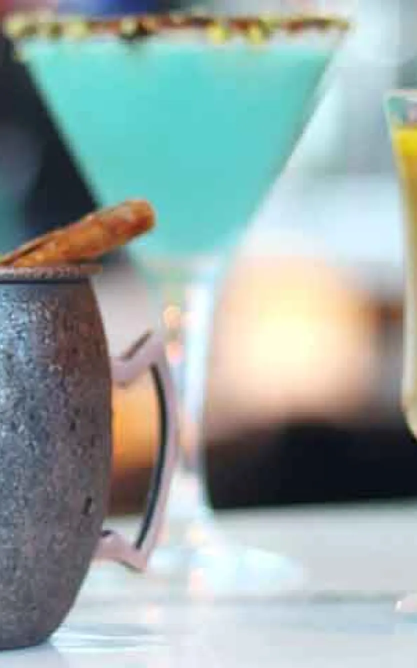 lineup of colorful cocktails sitting on a counter