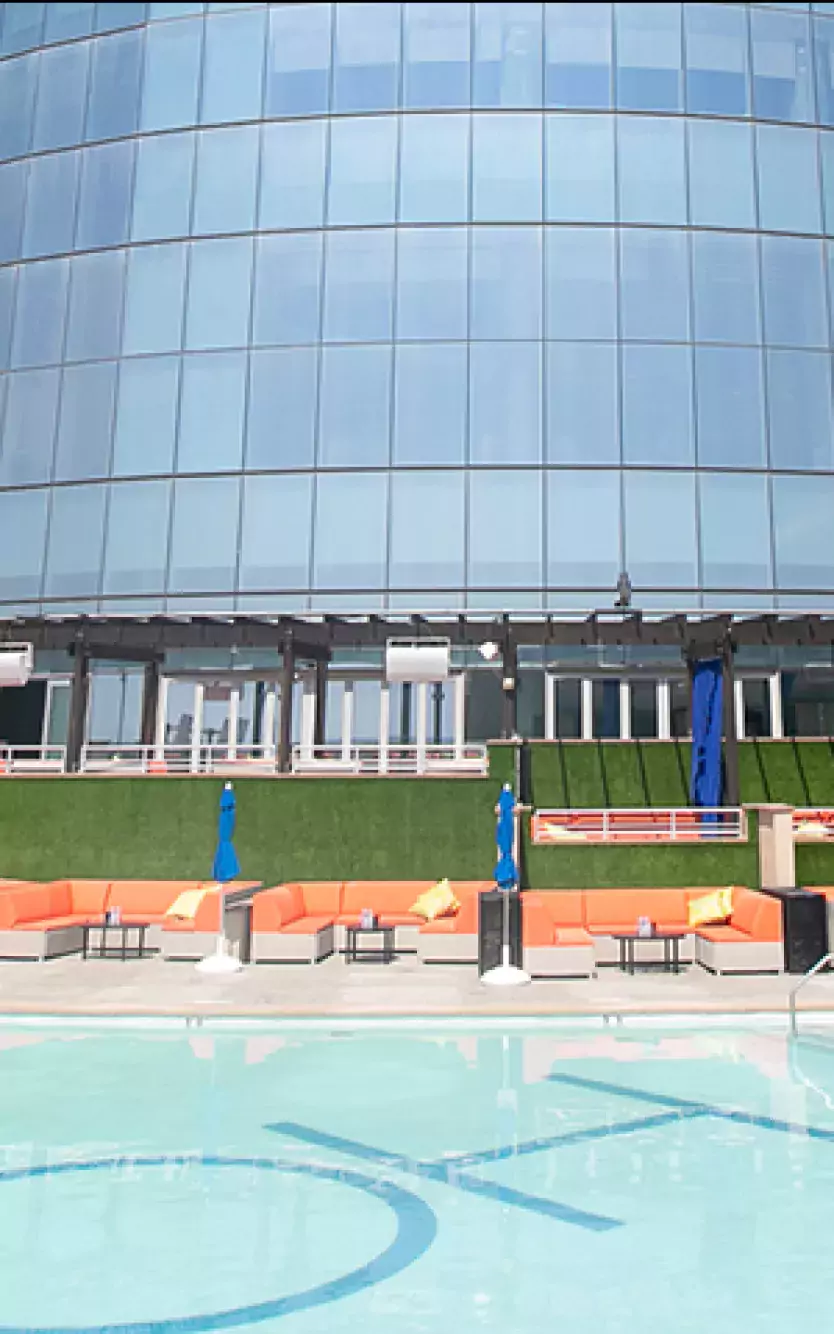 HQ2 Beachclub pool deck with lounge chairs and building in the background