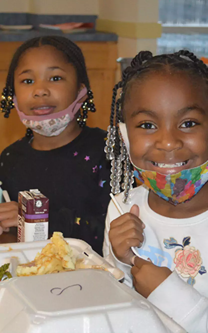 three-image collage of volunteers making Thanksgiving food, children eating and cooks holding food