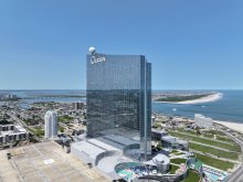 Outside of ocean casino resort in atlantic city. Greenery and the ocean are visible behind the gleaming skyscraper