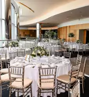 wedding reception with ocean views and tables decorated with fine table settings and floral arrangements