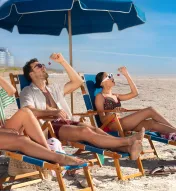 Three friends sitting on the beach in front of Ocean Casino Resort