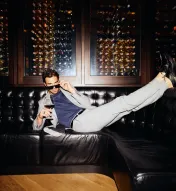 A man laying on the couch in at the SteakBar