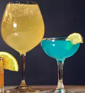 lineup of colorful cocktails in a variety of differently-sized cups