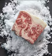 Wagyu Beef cut on a table next to an image of the upscale dining room at American Cut