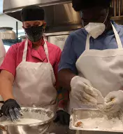 Three-image collage for the Boys &amp; Girls Club of Atlantic City with two people cooking together, a close-up of a sandwich, and a man pointing at the food someone else is holding