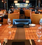 Three-image collage of fine-dining venues at Ocean Casino Resort, including a dining room with floor-to-ceiling windows, a close-up of a wooden dining table with wine glasses and an upscale dining room with tables and chairs