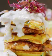A stack of fluffy waffles and fried chicken on a plate at Harper's Chicken and Waffles