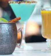 lineup of colorful cocktails sitting on a counter