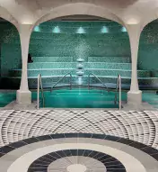 Tiled lounge area in with archways leading to spa pool