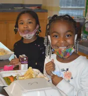 three-image collage of volunteers making Thanksgiving food, children eating and cooks holding food