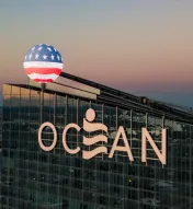 top of exterior of Ocean Casino Resort with American flag overlay in honor of Veteran's Day