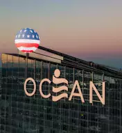 top of exterior of Ocean Casino Resort with American flag overlay in honor of Veteran's Day