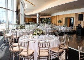 wedding reception with ocean views and tables decorated with fine table settings and floral arrangements